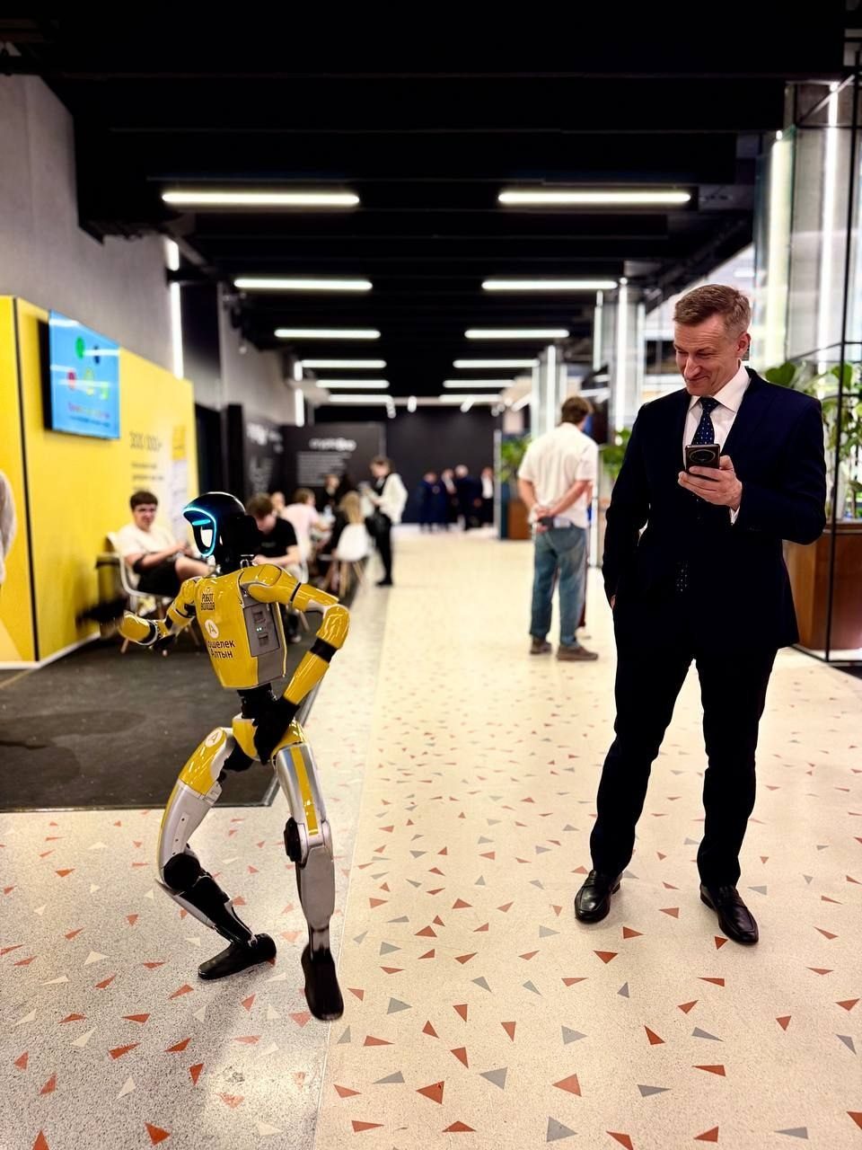 Vic Goncharuk next to a humanoid robot at a tech expo